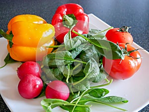 Fresh green vegetable salad with radish, tomatoes, color peppers