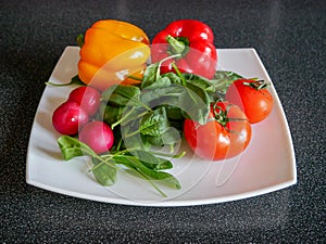 Fresh green vegetable salad with radish, tomatoes, color peppers