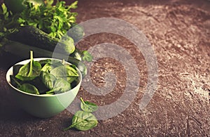 Fresh green vegetables in a bowl and on the table