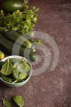 Fresh green vegetables in a bowl and on the table