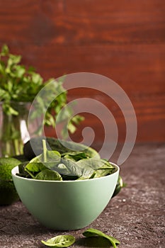 Fresh green vegetables in a bowl and on the table