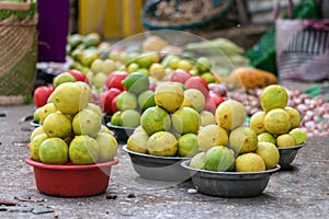 Fresh green and yellow lemons placed on baskets on the floor at the street market of Toliara, Madagascar