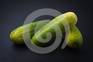 Fresh green zucchini or courgette isolated on dark background