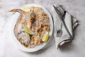 Fresh grilled dorado or sea bream fish with lemon and rosemary served with rice. Delicous dorada fish cooked on grill in seafood