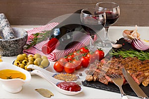 Fresh grilled meat. Grilled beef entrecote medium roast on black stone board, red wine and two full wine glasses.