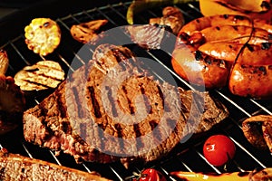 Fresh grilled meat steaks and vegetables on barbecue grate