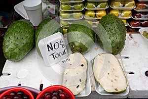 Fresh guabana or soursop fruit sold on the market with a sign saying do not touch (no tocar photo