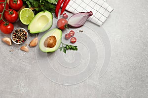 Fresh guacamole ingredients on grey table, flat lay. Space for text