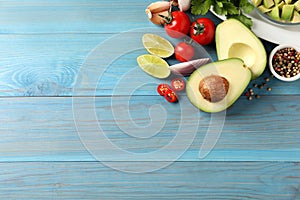Fresh guacamole ingredients on light blue wooden table, flat lay. Space for text