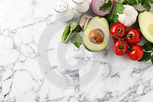 Fresh guacamole ingredients on white marble table, flat lay. Space for text