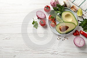 Fresh guacamole ingredients on white wooden table, flat lay. Space for text