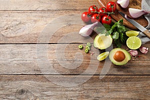 Fresh guacamole ingredients on wooden table, flat lay. Space for text