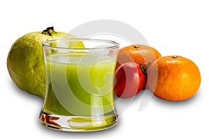 Fresh guava juice in transparent glass with ripe guava fruit, red tomato and oranges