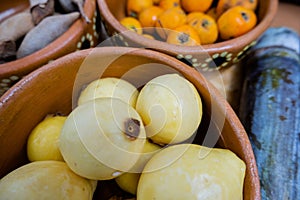 Fresh guavas, hawthorns, and tamarind in clay bowls