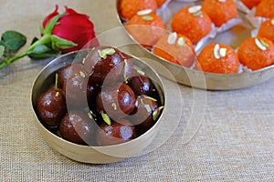 Fresh Gulab Jaman in plate with motichur laddu in background