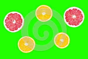 Fresh half cut grapefruit and orange isolated on green background. Close up view. Fruit concept. Healthy lifestyle concept.