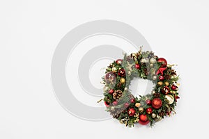 Fresh handmade christmas wreath decorated with red and gold Christmas decorations, fir-cones and walnuts.