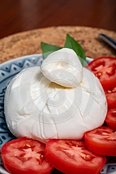 Fresh handmade soft Italian cheese from Puglia, white ball of burrata foglia saporosa or burratina cheese made from mozzarella and