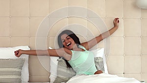 Fresh and happy woman in bed wakes up in the morning