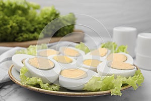 Fresh hard boiled eggs and lettuce on white marble table