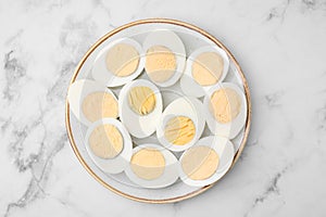 Fresh hard boiled eggs on white marble table, top view