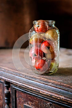 Fresh harvest of ripe and healthy farm apples in a glass jar, in a basket