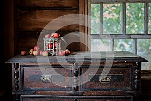 Fresh harvest of ripe and healthy farm apples in a glass jar, in a basket