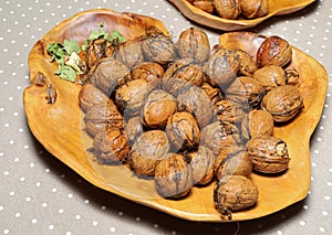 Fresh harvest walnuts with shells and water drops in wooden bowl. Walnuts details