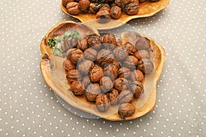 Fresh harvest walnuts with shells and water drops in wooden bowl. Walnuts details