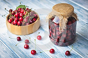 Fresh harvested cherry fruit and preserved fruit in jar