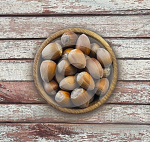 Fresh hazelnuts isolated on wooden background. Hazelnuts in a bowl with copy space for text. Hazelnut close-up on rustic table.
