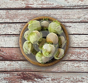 Fresh hazelnuts on wooden background. Hazelnuts in a bowl with copy space for text. Hazelnut close-up on rustic table.