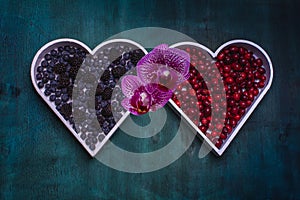 Fresh healthy berries in a white heart shape representing on dark vintage background - Healthy food, Vegetarian Valentine`s day