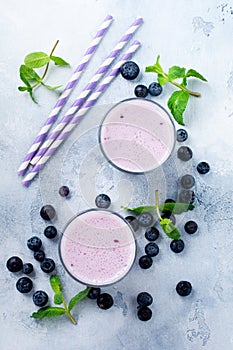 Fresh healthy blueberries smoothie berries and mint in glass on light white concrete background. Top view. Copy space