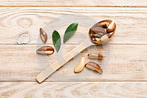 Fresh healthy brazil nuts in spoon on colored table background. Top view Healthy eating concept. Super foods