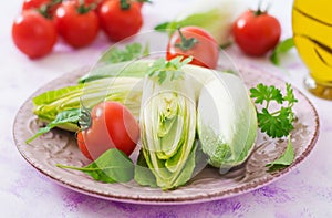 Fresh and healthy Chicory witloof Salad and tomato on a plate. Dietary menu.