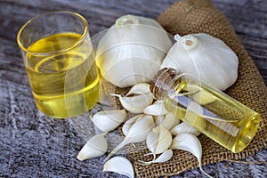 Fresh healthy garlic oil on the wooden background