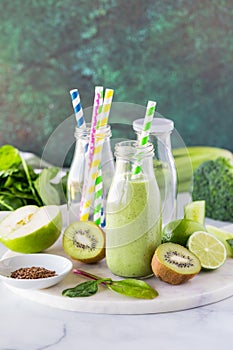 A fresh and healthy green smoothie in a glass bottle, ready for drinking.