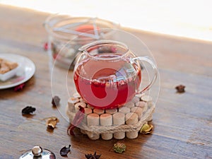 Fresh, healthy, herbal red tea with berries and dried fruits. A full teapot on a blurred table background. Copy space.