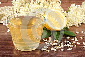 Fresh healthy juice, elderberry flowers and lemon on rustic board