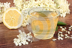 Fresh healthy juice, elderberry flowers and lemon on rustic board