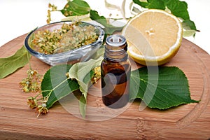 Fresh healthy linden flowers, lemon and tea with essential oil on a white background