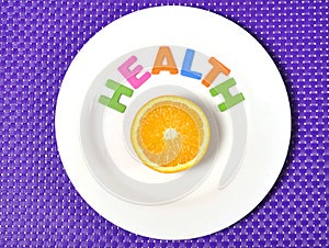 Fresh healthy Orange Fruit and health word on plate