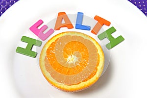 Fresh healthy Orange Fruit and health word on plate