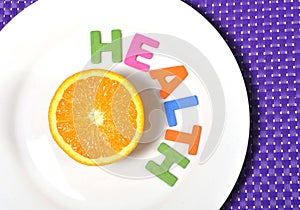 Fresh healthy Orange Fruit and health word on plate