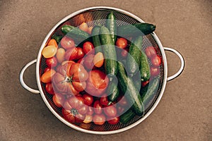 fresh healthy organic tomatoes and cucumbers in strainer