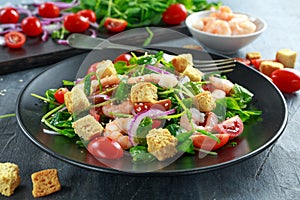 Fresh Healthy Prawns salad with tomatoes, red onion on black plate. concept healthy food