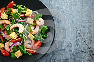 Fresh Healthy Prawns salad with tomatoes, red onion on black plate. concept healthy food