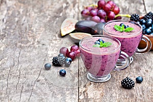 Fresh healthy pulpy cocktail with purple fruits and berries