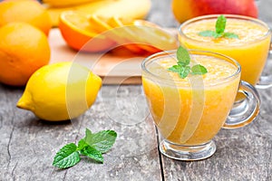 Fresh healthy pulpy juice with orange fruits and vegetables photo